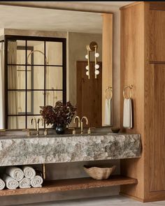 a bathroom with marble counter tops and gold faucets on the sink, along with towels