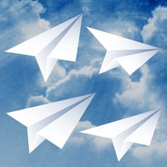 three white paper airplanes flying in the sky