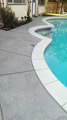 an empty swimming pool next to a house