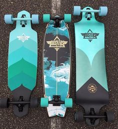 two skateboards sitting next to each other on top of a street floor with blue and green wheels