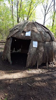 a small hut in the woods with signs on it