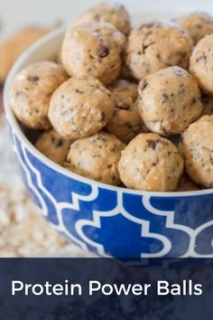 a blue and white bowl filled with protein power balls on top of a table next to cookies