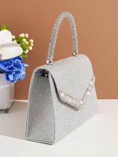 Introducing the perfect accessory for the party perfect bride - the Shimmer and Shine: Glitter Handbag. Made with glimmering glitter, this handbag will add a touch of sparkle to any wedding ensemble. Stay stylish and organized with this must-have bag. Color : Silver Details : Rhinestone Magnetic : Yes Strap Type : Chain Style : Glamorous Pattern Type : Plain Bag Size : Small Closure Type : Magnet Type : Square Bag Material : Glitter Composition : 100% Polyester Care Instructions : Do not wash Size Bag Height Bag Length Bag Width Handle Height Strap Length one-size 14.5 22 7 9 120 Handheld Sequined Evening Bag For Parties, Glamorous Glitter Bag For Evening, Silver Glamorous Evening Bag For Party, Glitter Clutch Evening Bag For Event, Glitter Clutch Evening Bag For Events, Glamorous Glitter Rectangular Evening Bag, Glitter Rectangular Evening Bag For Party, Glamorous Handheld Bag For Prom, Elegant Glitter Bag For Events