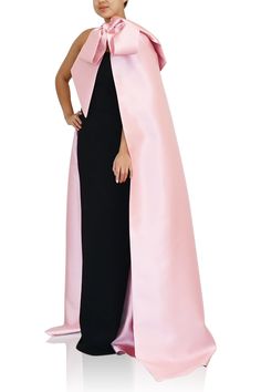 From Greta Constantine, the LEYA gown. This elegant black column gown features a rose pink caplet detailing. Dramatic and beautiful! Capelet: 51% Silk, 49% Wool, Dress: 68% Polyamide, 32% Elastane, Lining: 100% Silk *Note that made-to-order pieces take 22 - 26 weeks to ship. Pink Wedding Gown With Cape Sleeves, Pink Gown With Cape Sleeves, Evening Gown With Sweep Train And Cape, Pink Evening Dress With Cape Sleeves For Formal Occasions, Pink Evening Dress With Cape Sleeves For Formal Events, Pink Formal Evening Dress With Cape Sleeves, Chic Gown With Cape Sleeves For Gala, Chic Gala Gown With Cape Sleeves, Elegant Pink Gown With Cape Sleeves