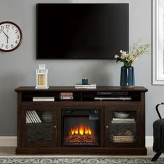 a living room with a television and fire place in front of the tv on the wall