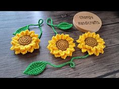 three crocheted sunflowers on a wooden table