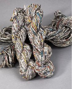 several skeins of multicolored yarn on a gray surface with one knot in the middle