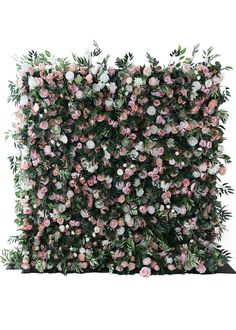 an artificial flower wall with pink and white flowers on the top, surrounded by greenery