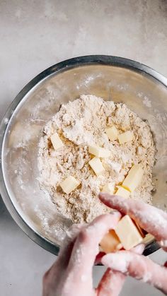 someone is mixing ingredients in a metal bowl