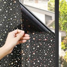 someone is holding the window with their hand and reaching for the star pattern on it