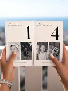 a person holding up two photos with the number one on them in front of an ocean view