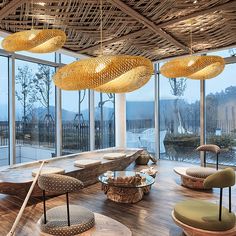 a living room filled with lots of furniture and large glass windows covered in bamboo coverings