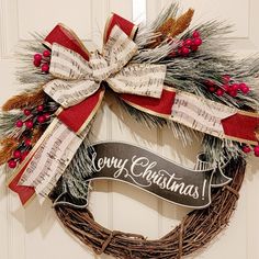 a christmas wreath hanging on a door with a merry christmas sign in the middle and ribbon around it