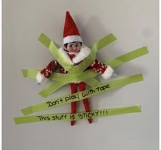 an elf is holding a green piece of paper with the words don't play with tape, this stuff is sticky