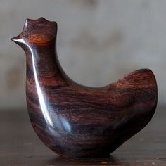 a wooden bird sculpture sitting on top of a table