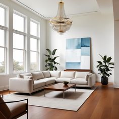 a living room filled with furniture and a chandelier hanging over the top of it