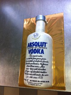 a bottle of absolut vodka sitting on top of a metal counter next to a bag