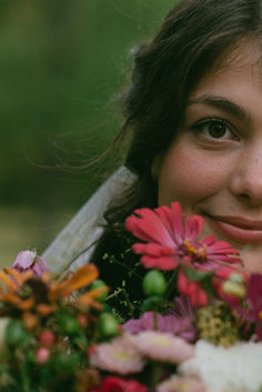 a woman holding flowers in her hands and smiling