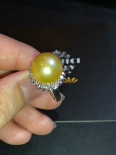 Huge GOLDEN SOUTH SEA PEARL, absolutely natural color and TOP AAA+ luster, 14 mm in size, surrounded by 22 pieces of hand-set E/VS superb quality diamonds, weighting at 0.72 carat. Set in handcrafted, one of a kind 18K solid white gold ring, weighting at 11.0 grams. The pearl is naturally cultured from South Australia Sea, its luster is EXTREMELY FINE, AA+ grade with 90% clean surface. SUGGESTED RETAIL PRICE: $9,800 The ring is hand crafted to a high standard and is NOT mass machine produced and Silver Pear-shaped Platinum Ring, Silver Platinum Pear-shaped Ring, Luxury Pear-shaped Diamond Ring Gift, White Gold Pearl Ring With High Luster Diamonds, Exquisite High Luster Diamond Ring, Diamond Pearl Ring With High Luster For Gift, Gift Pearl Ring With High Luster And Diamond, Diamond Rings Suitable For Gift, Golden South Sea Pearls