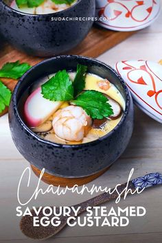 two black bowls filled with food on top of a wooden table