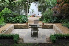 an outdoor patio with chairs and tables surrounded by greenery