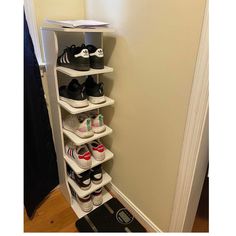 there is a shoe rack with shoes on it in the corner next to a door