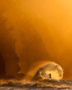 a person riding a wave on top of a surfboard in the ocean at sunset