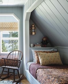 a bedroom with a rocking chair next to a bed and window in the wall above it