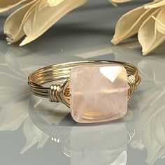 "Handmade Square Rose Quartz Gemstone and Sterling Silver, Yellow or Rose Gold Filled Wire Wrapped Ring; Custom Made to Size Experience the beauty and elegance of this stunning Rose Quartz Ring. This ring features a square gemstone that has been skillfully wire-wrapped in your choice of wire metal type for the band. The gemstone is custom made in multiple sizes, from 4 to 14, so you can find the perfect fit for your finger. The warm hues of the Rose Quartz gemstone are perfectly complemented by Adjustable Rose Quartz Rose Gold Ring, Adjustable Rose Quartz Jewelry In Rose Color, Adjustable Rose Quartz Rose-colored Jewelry, Adjustable Rose Quartz Ring, Handmade Adjustable Pink Crystal Ring, Handmade Adjustable Rose Quartz Rings, Wire Wrapped Rose, Ring Square, Rose Quartz Ring