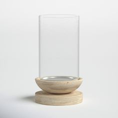 a glass vase with a wooden base on a white background, it appears to be empty