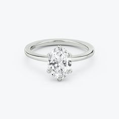 an oval cut diamond ring on a white background with the center stone in the middle