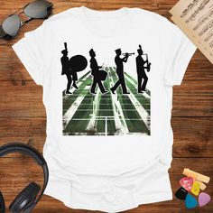 🎵 Get ready for some Marching Band Fun with our Marching Band Field T-Shirt! This awesome shirt is inspired by the Abby Road cover and perfect for any Marching Band Shirt collection. It makes a fantastic Music Teacher Gift or Band Director Gift. Whether you're part of a School Band or a College Band, this shirt is a great way to show your spirit. Perfect for any music lover, this tee celebrates the joy of marching bands! 🎶 👕 Premium Quality: Softstyle Tee for ultimate comfort ⚤ Stylish UNISEX Music-themed Screen Print Tops For Music Festivals, Band Logo T-shirt For Fans, Music-themed White Screen Print Tops, Music-themed Screen Print Shirt For Concert, Band Logo T-shirt Fan Apparel, White Music-themed T-shirt For Fans, Music-themed Short Sleeve Tops For Fan Merchandise, Music-themed Fan Merchandise Tops With Short Sleeves, Music-themed Screen Print T-shirt For Concert