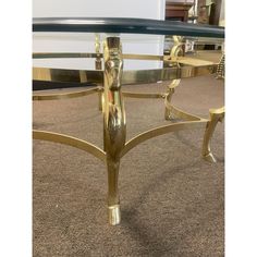 a glass and gold coffee table on carpeted floor