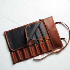 an open leather case on the floor with two ties and one wallet in it's pocket