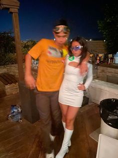 a man standing next to a woman on top of a wooden floor in front of a trash can