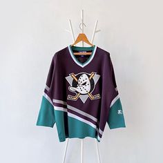 a hockey jersey hanging on a rack with a coat hanger in front of it