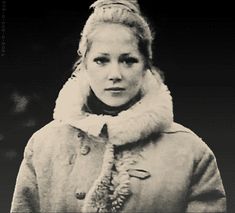 black and white photograph of a woman wearing a fur collared coat with a scarf around her neck