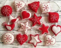 some red and white ornaments are hanging on a wooden table with string attached to them