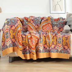 a couch covered in an orange and blue blanket