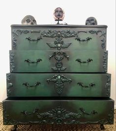 an ornate green dresser with skulls on top