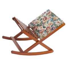 a wooden rocking chair with a cushion on it's back and floral print seat pad