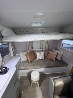 the inside of a camper with couches and pillows on it's sides