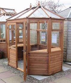 a wooden gazebo sitting in the middle of a yard