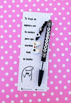 a black pen sitting on top of a white and pink polka dot covered tablecloth