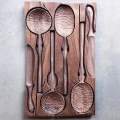 spoons and spatulas are arranged on a wooden board