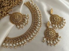 the necklace and earring are adorned with pearls