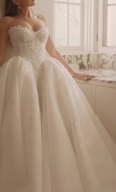 a woman in a wedding dress leaning against a wall