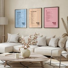 a living room with couches, tables and posters on the wall above it's coffee table