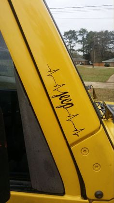 the side window of a yellow truck with writing on it