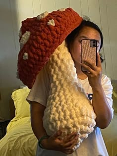 a woman taking a selfie with her cell phone while wearing a knitted hat